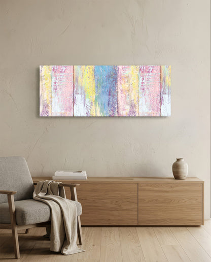 Pastel-colored painted wood wall art with pink, yellow, and blue vertical stripes hanging above wooden furniture in a minimalist interior.