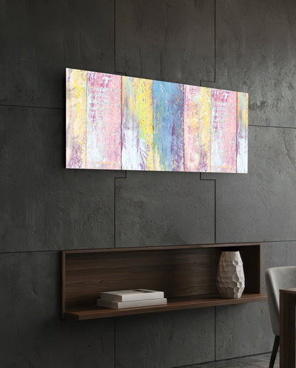 Horizontal painted wood glass wall art displaying vertical stripes in pastel pink, yellow, and blue hung above a dark wooden shelf.