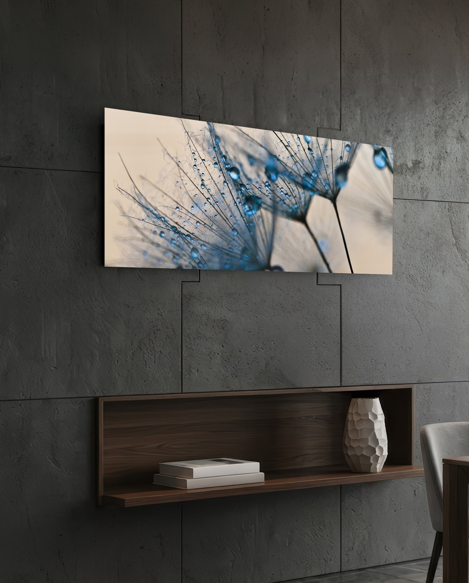 Macro Dandelion Glass Wall Art mounted on dark concrete wall above wooden shelf, displaying blue water droplets on delicate seedhead against cream background.