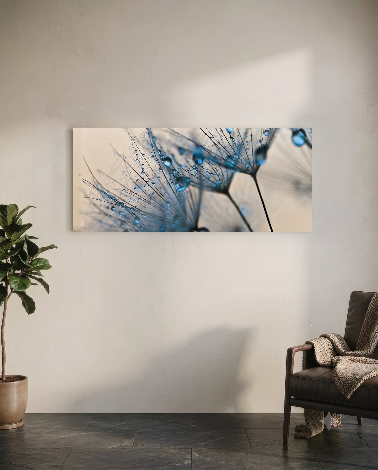 Macro Dandelion Glass Wall Art mounted on white wall above chair, showing blue-tinted dandelion seedheads with water droplets against cream background.
