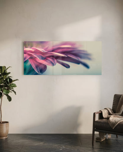 Macro glass wall art mounted above a chair showing pink flower petals in soft focus with teal gradient background.