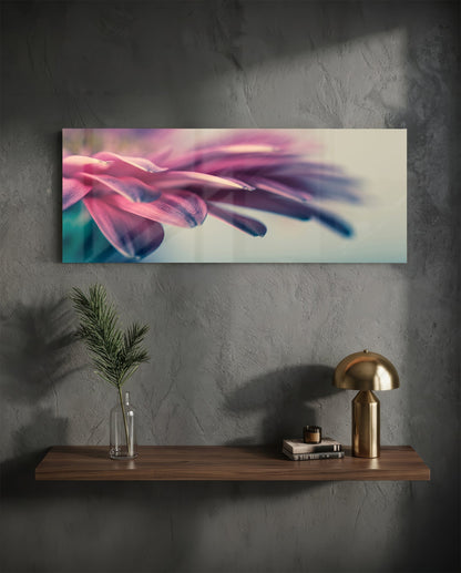 Macro glass wall art displaying close-up pink and purple flower petals with soft focus, mounted above wooden shelf with brass lamp and plant.
