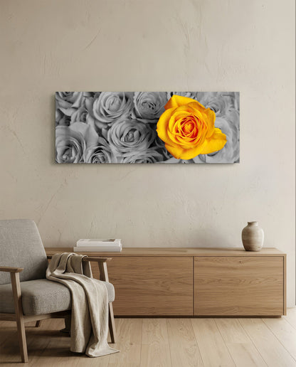 Yellow rose glass wall art displayed above wooden dresser in minimalist living room with gray chair and beige wall.