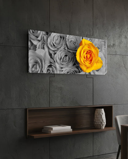 Yellow rose glass wall art hung above wooden shelf on concrete wall, displaying black and white roses with one vibrant yellow rose.