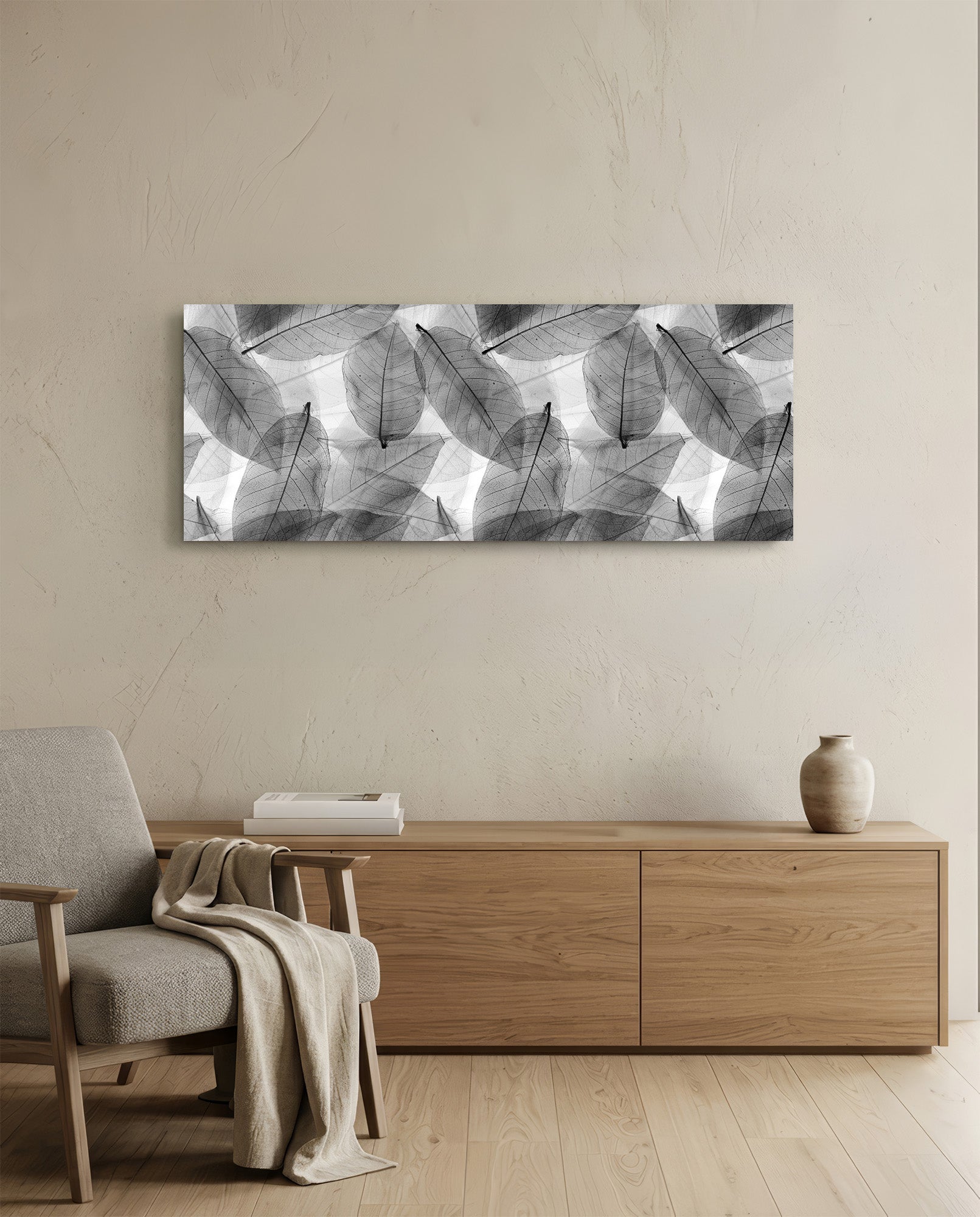 Black and white translucent leaf pattern glass art displayed above wooden dresser in minimalist living room interior.