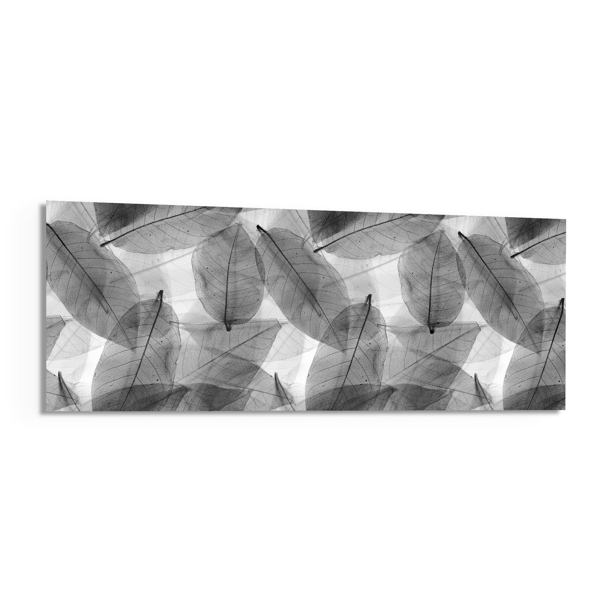 Black and white glass wall art panel displaying overlapping translucent leaves in grayscale tones.