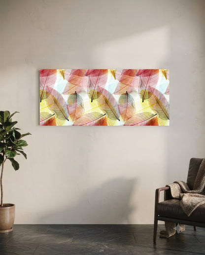 Translucent colored leaf glass art panel mounted on white wall above chair, displaying pink, red, yellow, and green autumn leaves.