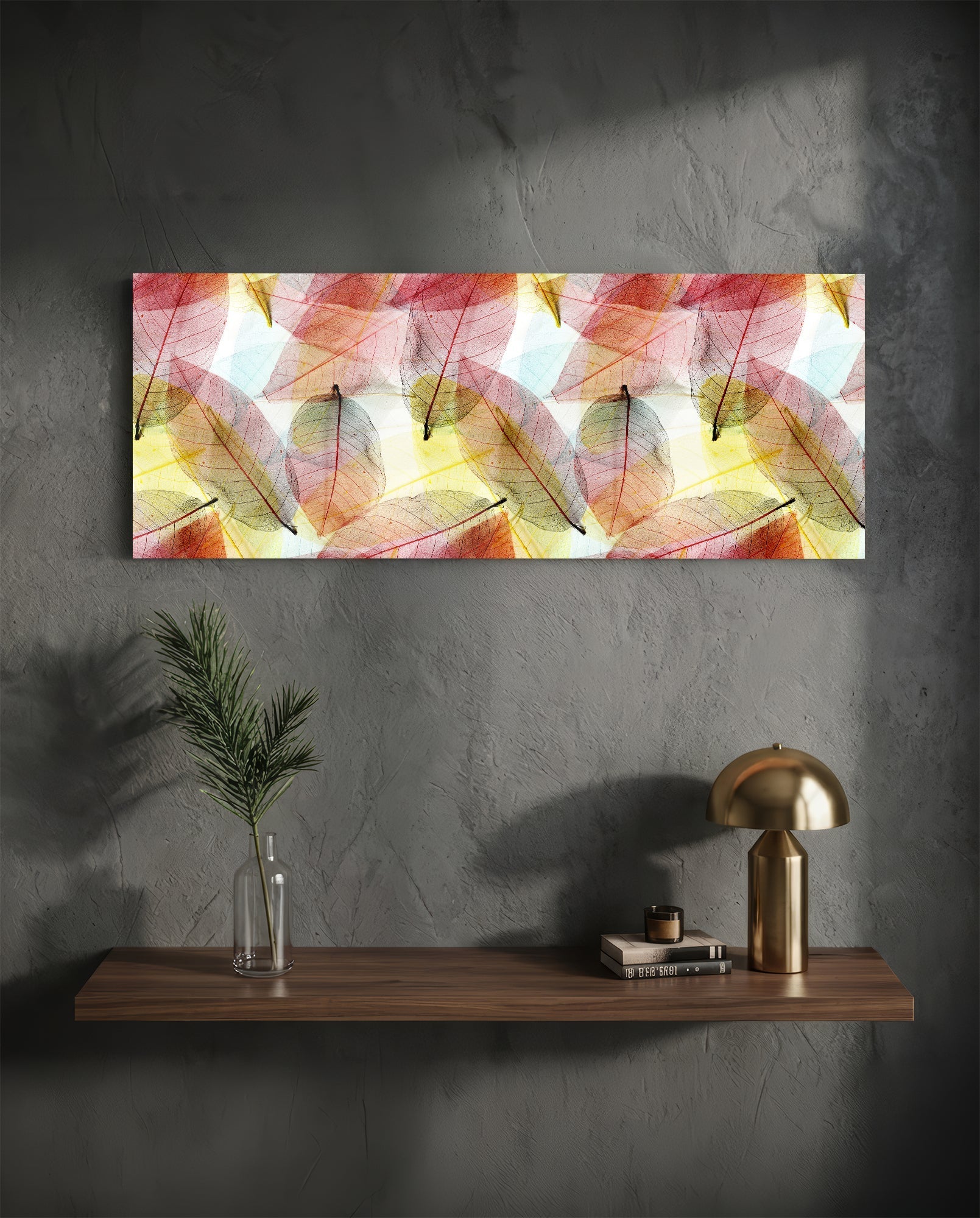 Horizontal glass wall art with translucent red, pink, and yellow leaves displayed above a wooden shelf with decorative items.