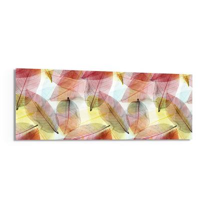 Translucent autumn leaves in red, yellow, and pink tones arranged in a repeating pattern on rectangular glass wall art against white background.