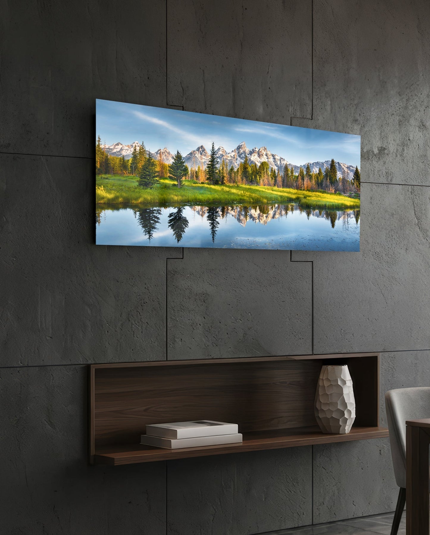 Spring Glass Wall Art mounted on concrete wall above wooden shelf, showing mountain landscape with reflected trees in still water.