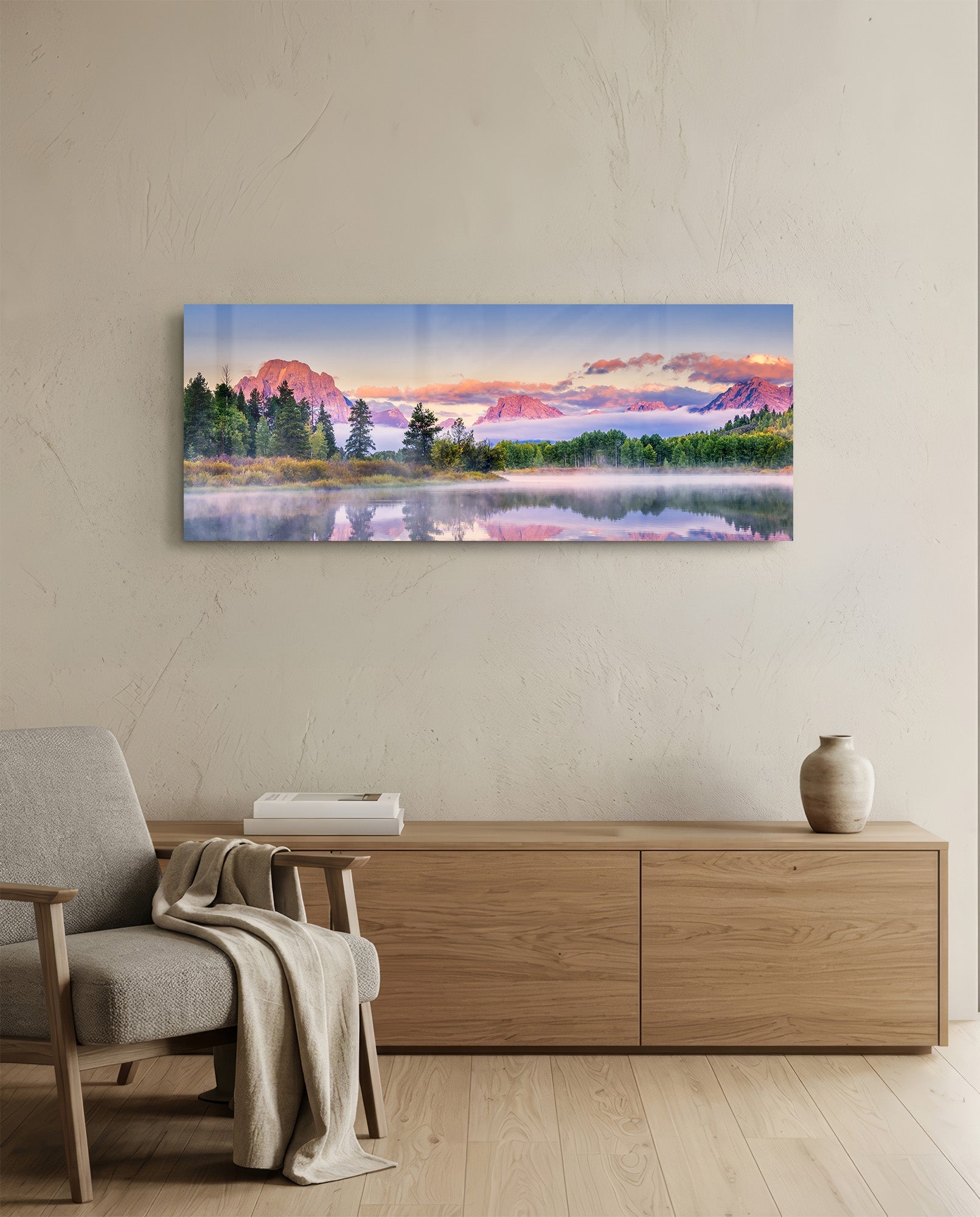 Panoramic glass art hung above wooden dresser showing misty lake with pink-toned mountains and evergreen trees at sunrise.