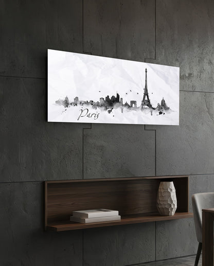 Paris skyline watercolor art in black and gray on white glass panel mounted above wooden shelf on concrete wall.