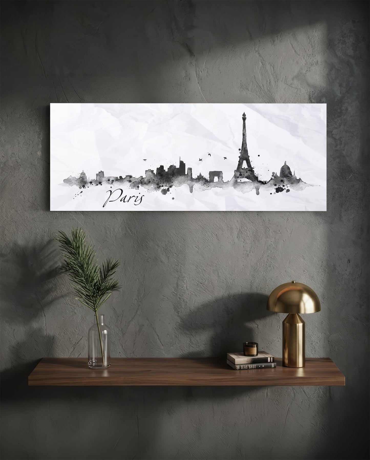 Horizontal Paris skyline watercolor art print in black ink on white glass hanging above wooden shelf with gold lamp and plant.