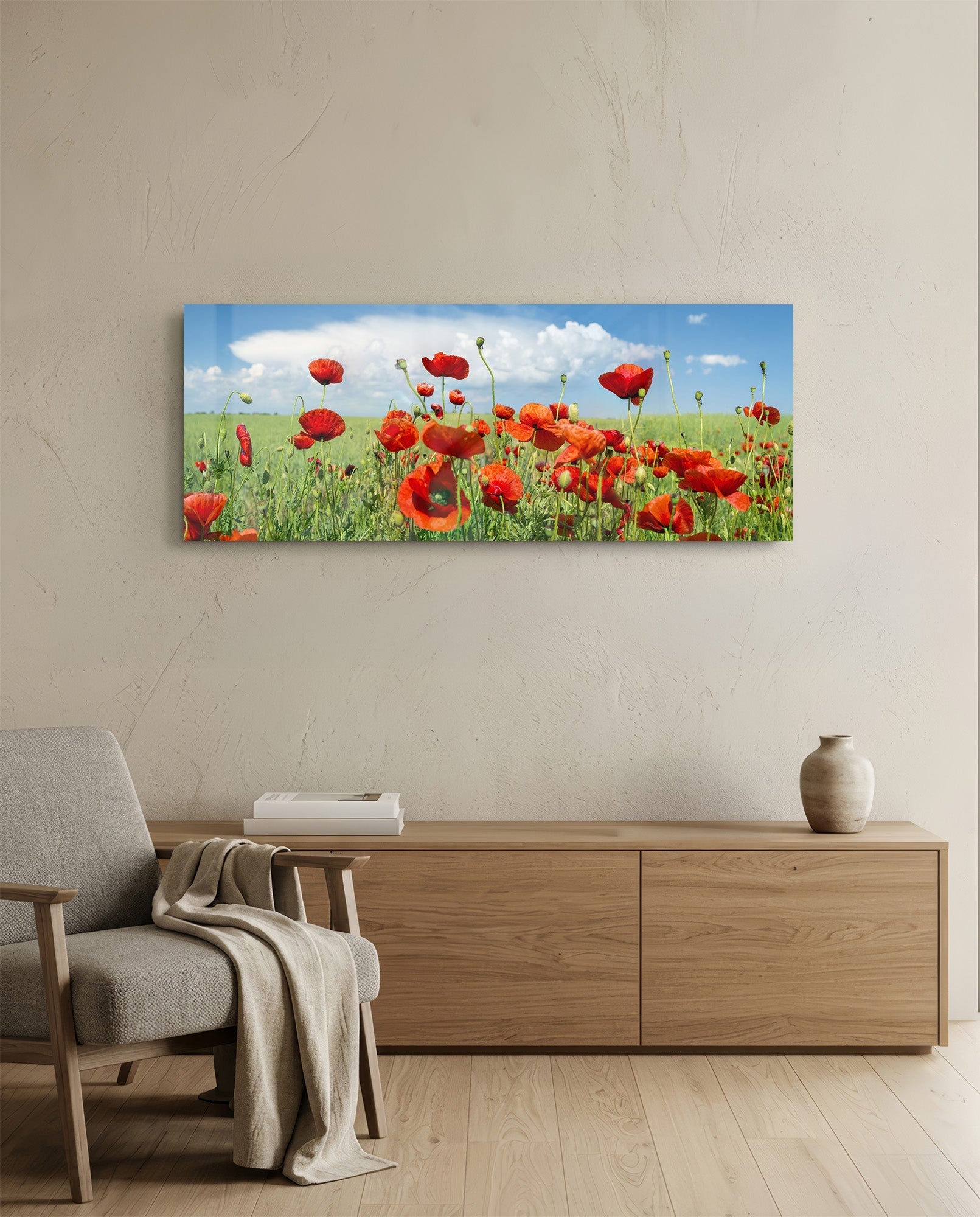 Landscape glass art depicting red poppies in green field with blue sky, hung above wooden dresser in modern living room.