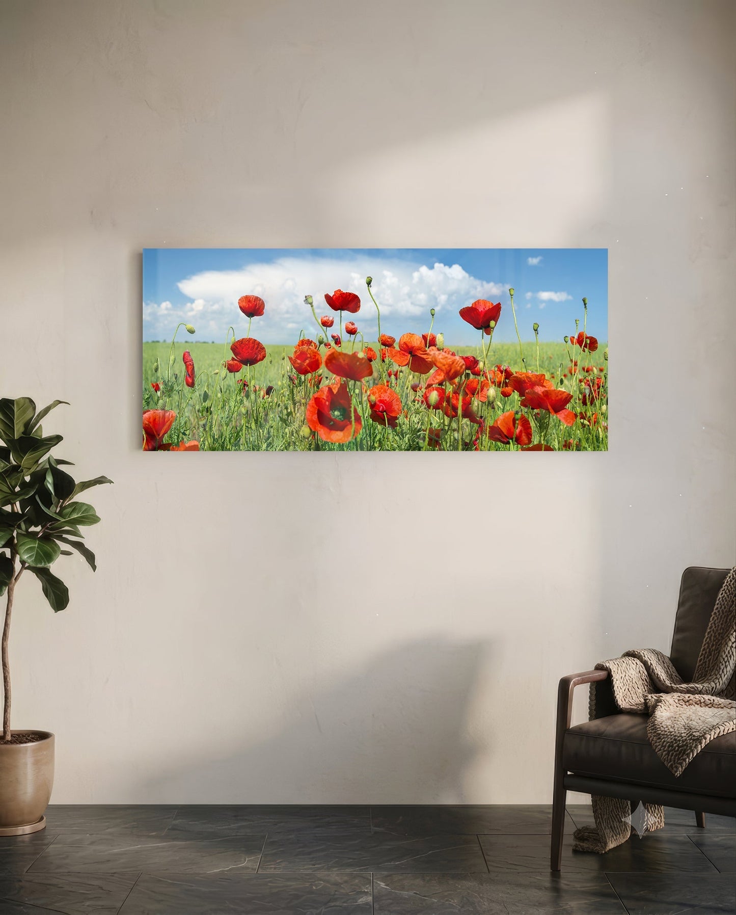 Glass wall art depicting a vibrant red poppy field with green stems against a blue sky with white clouds, mounted horizontally on a white wall.