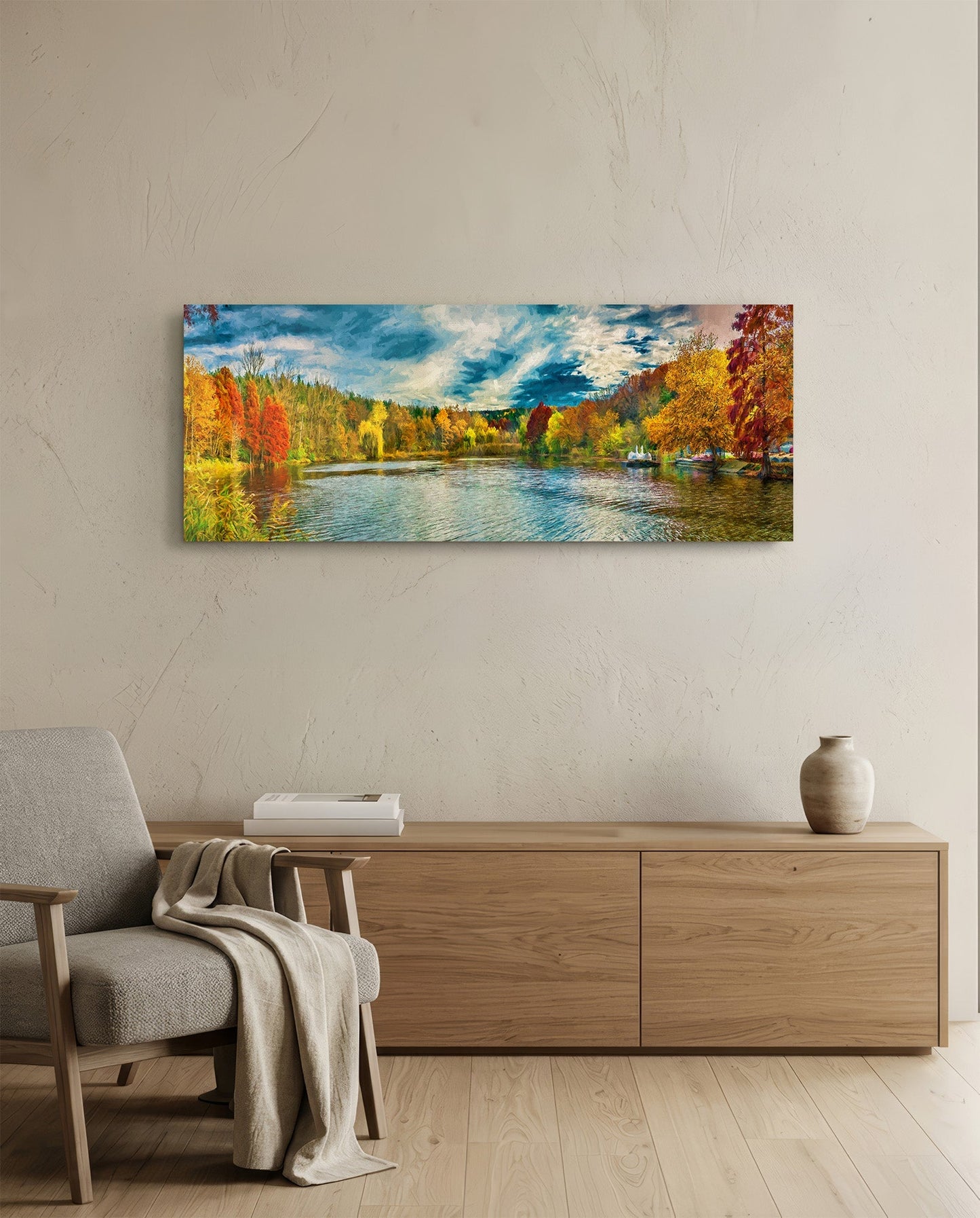 Panoramic autumn landscape glass wall art displaying a river lined with golden and red trees under a blue cloudy sky, hung above a wooden console.