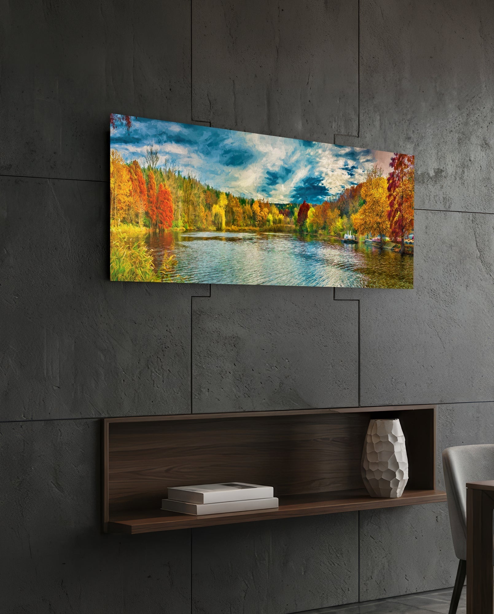 Horizontal glass wall art displaying autumn lakeside landscape with colorful fall trees, blue water, and sky, mounted on concrete wall above wooden shelf.