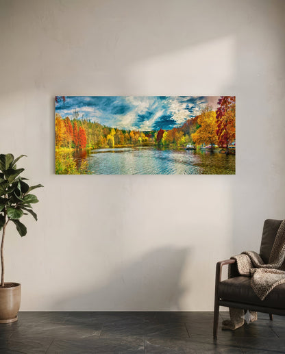 Horizontal glass wall art depicting an autumn river landscape with colorful fall foliage, blue water, and cloudy sky, displayed above a chair in a minimalist interior.