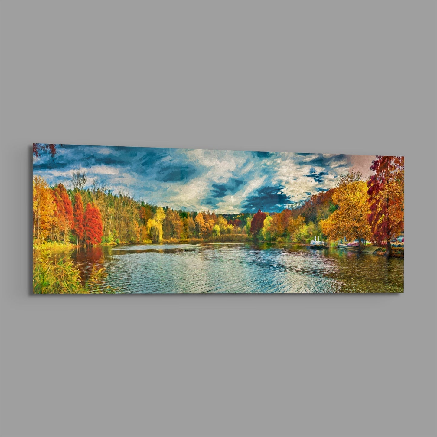 Panoramic glass wall art depicting an autumn lakeside landscape with colorful fall foliage, blue water, boats, and cloudy sky.