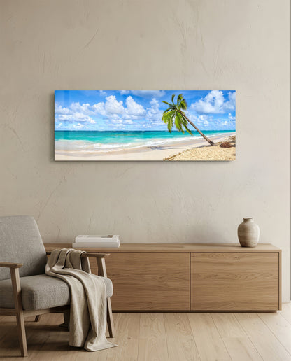 Tropical beach glass wall art displayed above wooden dresser in neutral interior, showing palm tree, sand, turquoise ocean, and blue sky.