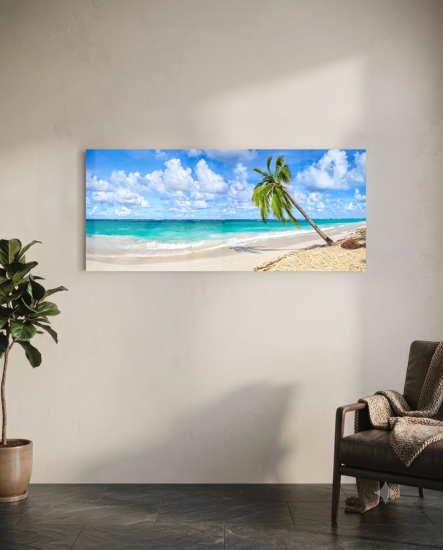 Palm tree glass wall art hanging on white wall above leather chair, showing tropical beach scene with turquoise ocean and white sand.