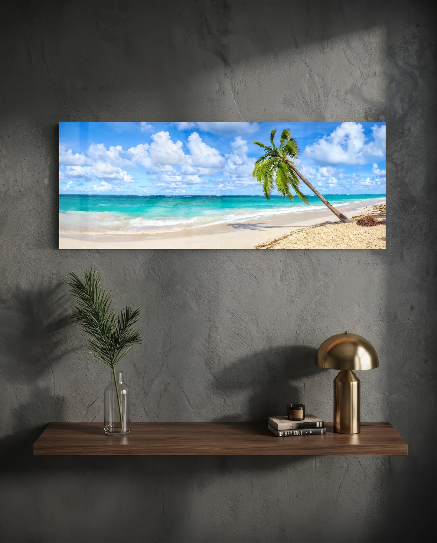 Horizontal glass wall art displaying a tropical beach scene with leaning palm tree, turquoise water, and white sand, mounted above wooden shelf.