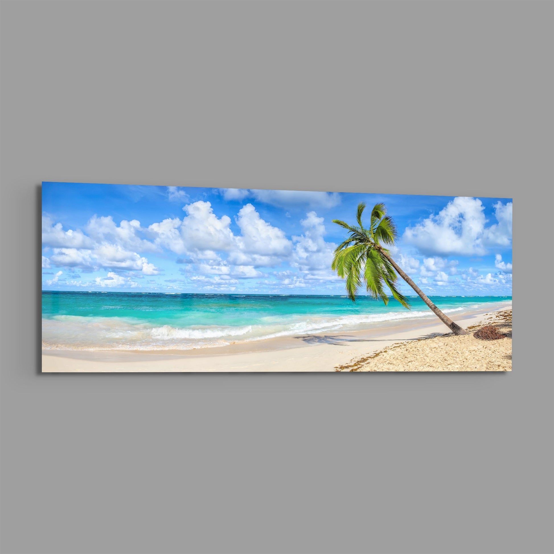 Panoramic glass wall art displaying a tropical beach scene with a leaning palm tree, turquoise water, white sand, and blue sky with white clouds.
