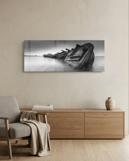 Black and white shipwreck glass wall art displayed above wooden dresser in minimalist interior setting.
