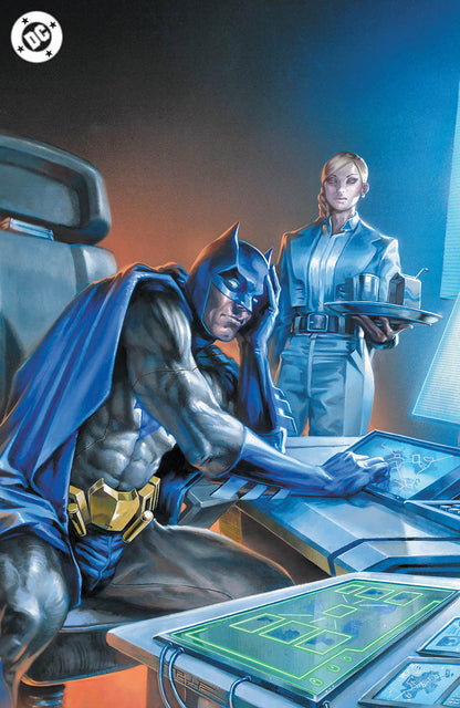 Batman, head in hands, sits at a glowing map table while a blonde woman in a blue suit holds a tray.