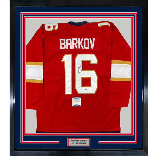 Framed red Florida Panthers hockey jersey number 16 with "BARKOV" nameplate and signature, displayed flat against white backing with navy and red border matting.
