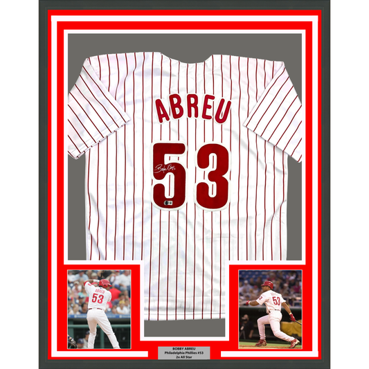 Framed white pinstriped baseball jersey displaying "ABREU" and number 53 with signature, flanked by two action photos of the player.