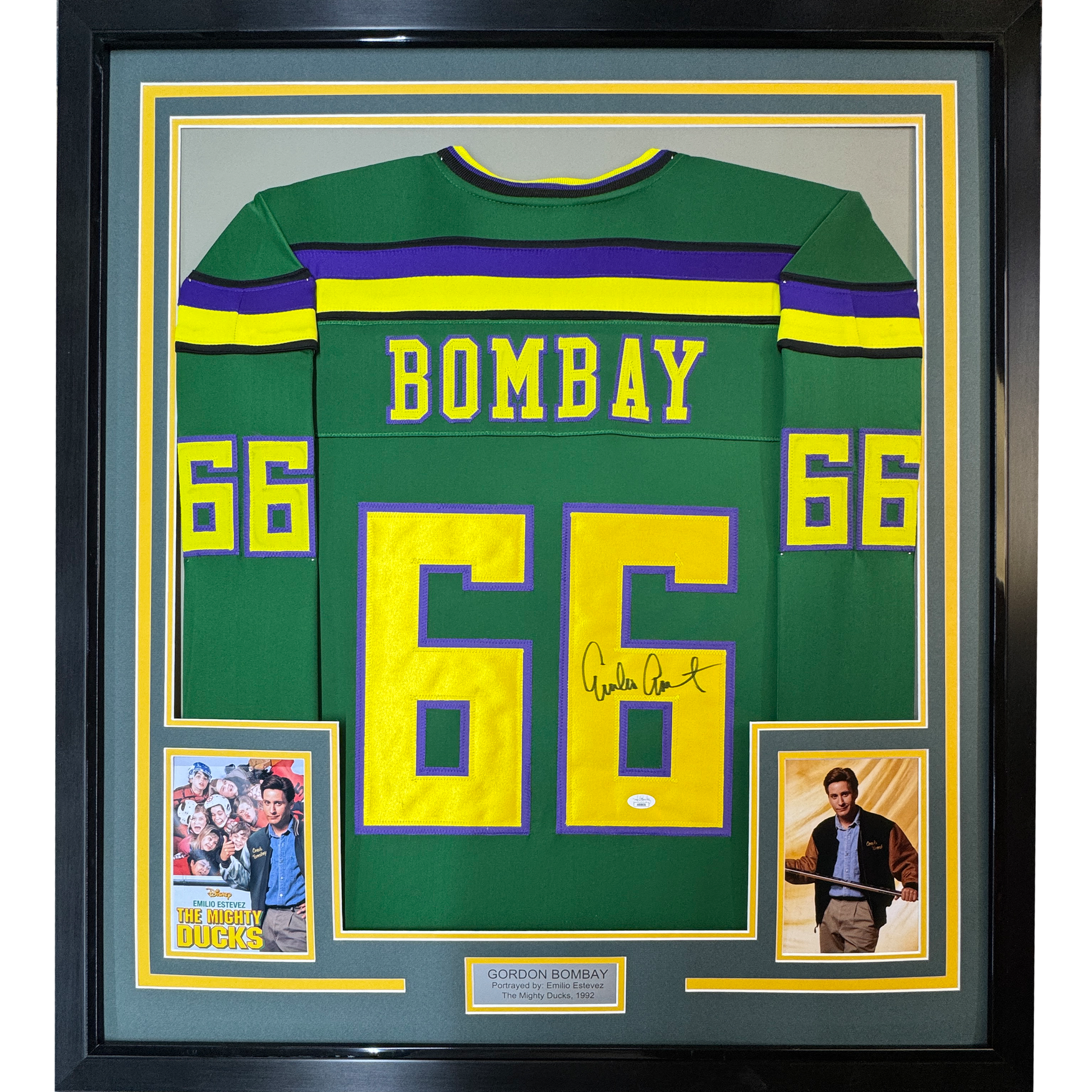 Framed green hockey jersey with "BOMBAY" and number 66 in yellow, signed by Emilio Estevez, flanked by two photos from The Mighty Ducks movie.