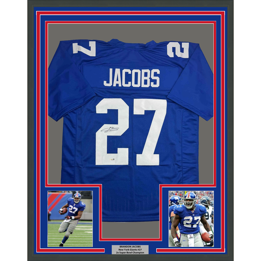 Framed blue New York Giants jersey number 27 signed by Brandon Jacobs with two action photographs below.