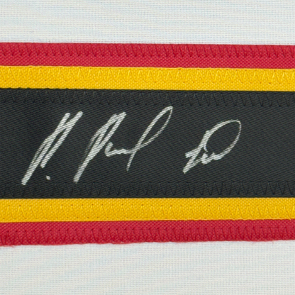 Close-up of horizontal striped fabric trim with handwritten signature on black stripe between red, yellow, and white bands.