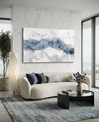 Blue Fog Glass Wall Art displayed above cream curved sofa in modern marble living room with black coffee table.