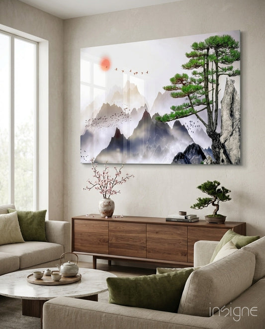 Abstract forest glass wall art featuring misty mountains, a bonsai tree, and red sun displayed above wooden furniture in a modern living room.