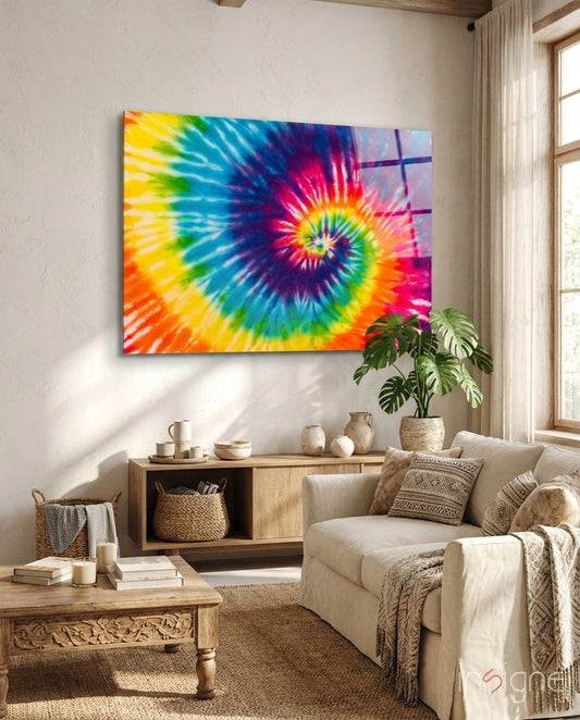 Vibrant tie-dye rainbow mosaic glass art hung above wooden furniture in a neutral, light-filled living room.