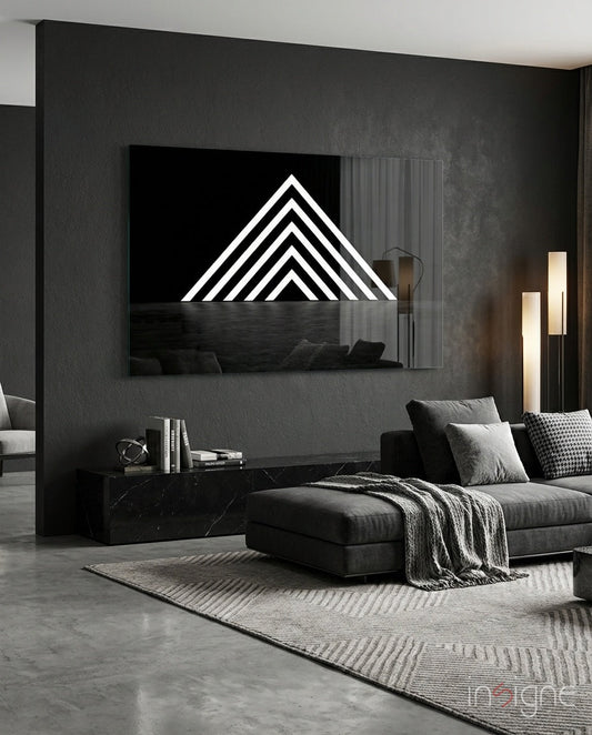 Modern living room displaying glowing white chevron pyramid neon wall art mounted above black marble side table and dark sectional sofa.