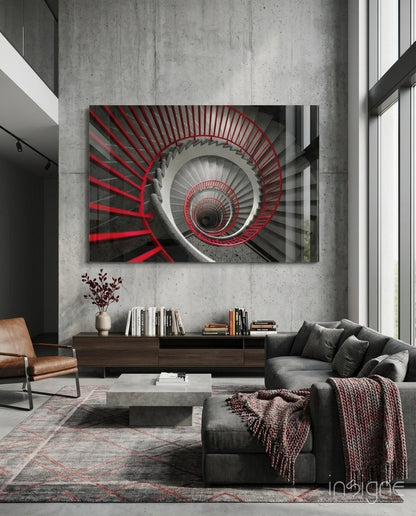 Red and gray spiral staircase glass wall art displayed above wooden console in modern living room with concrete walls.