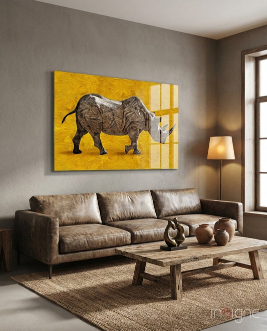 Golden yellow glass wall art depicting a detailed rhinoceros displayed above a brown leather sofa in a modern living room.