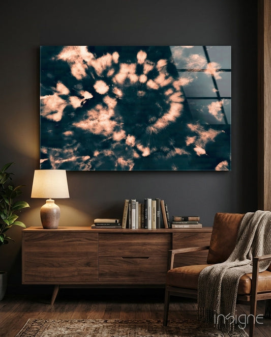 Peach dandelion spiral design on navy glass displayed above a wooden dresser with lamp and books in a modern living room setting.