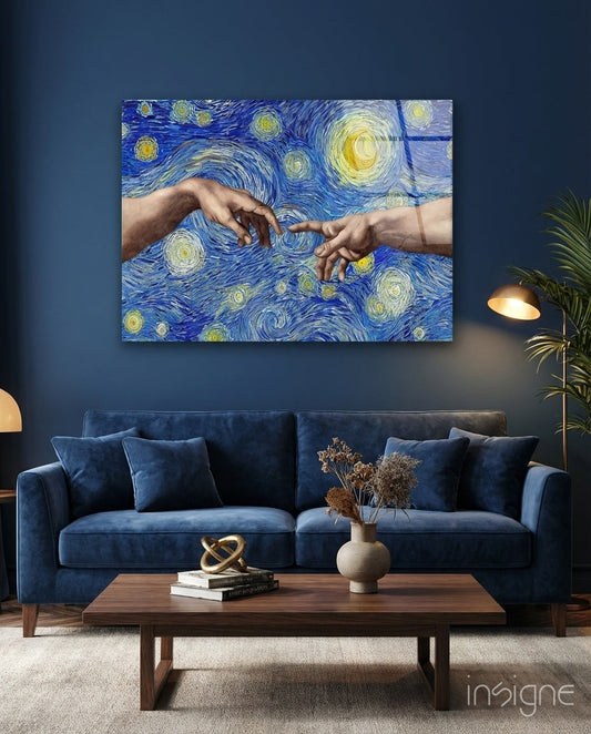 Blue glass wall art depicting two hands reaching toward each other against swirling starry background, displayed above navy sofa in living room.