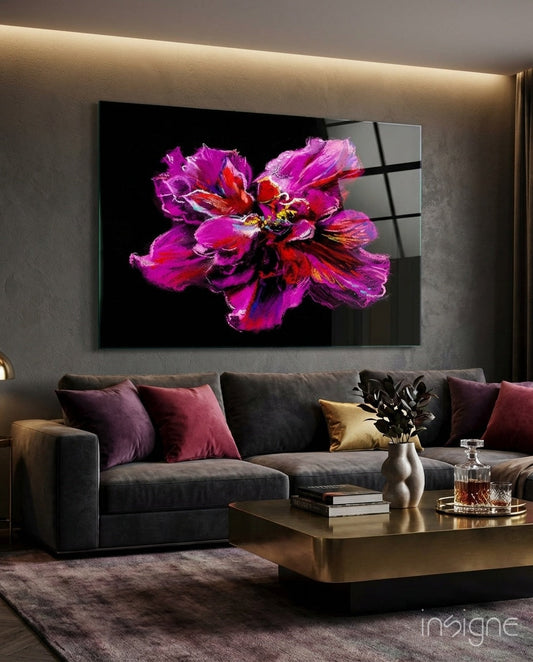 Magenta and red painted peony glass wall art displayed above a dark sofa in a modern living room with warm accent lighting.
