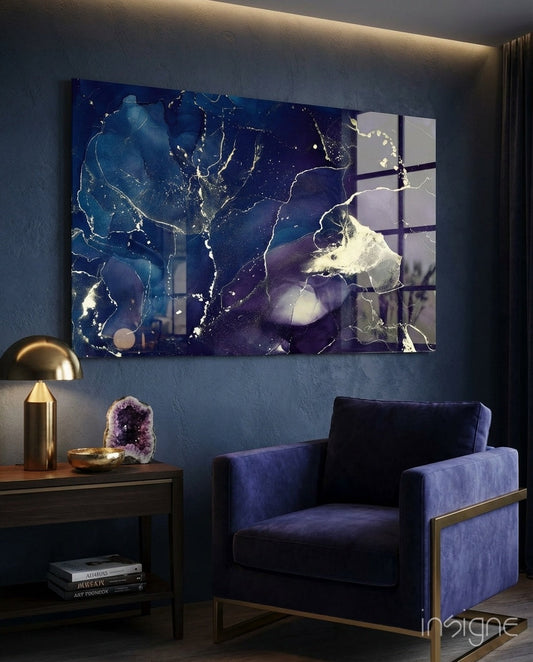 Midnight Navy Gold Ink Glass Wall Art displayed above a blue velvet chair in a styled living room interior with brass accents.