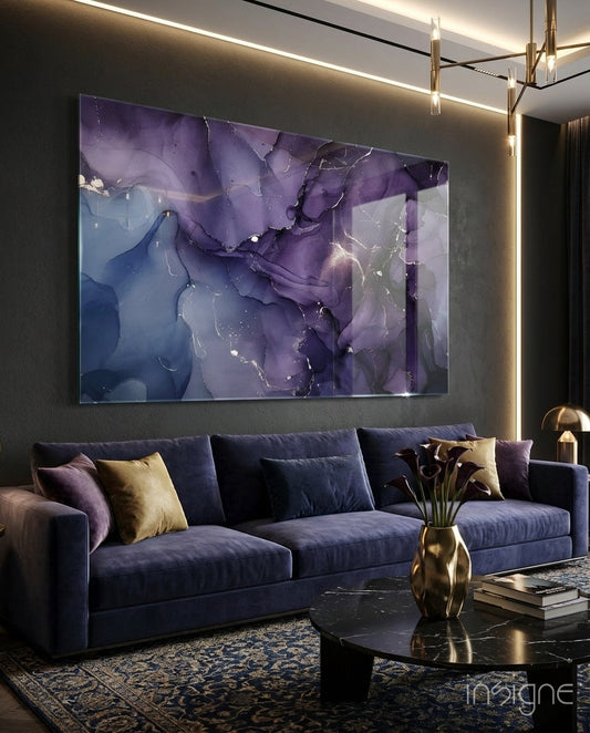 Purple and blue abstract ink glass wall art displayed above a navy sofa in a modern living room setting.
