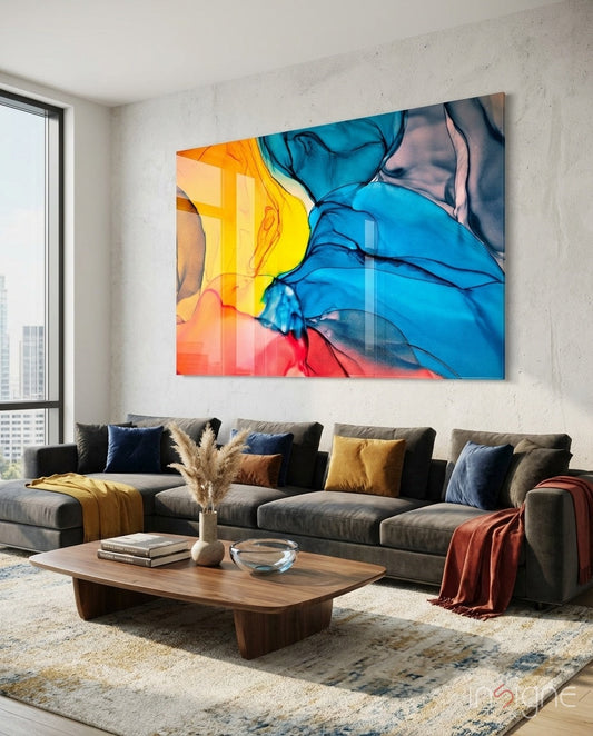 Colorful abstract blue, yellow, and red ink flow glass art displayed above a gray sectional sofa in a modern living room.