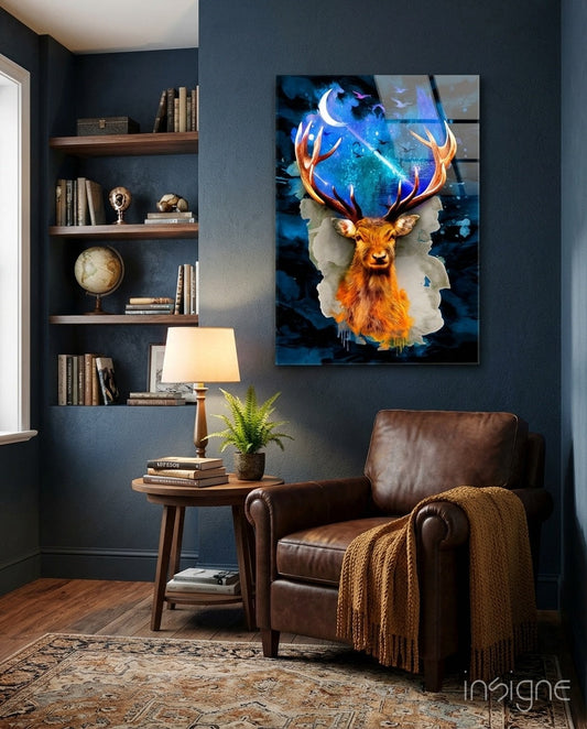 Cosmic Galaxy Antler Stag glass wall art displaying a golden deer head with glowing blue celestial antlers, hung in a dark blue study room above a leather chair.