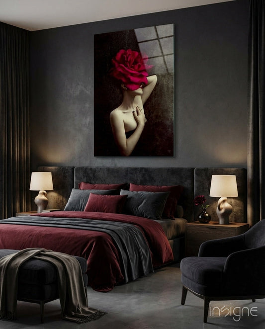 Glass wall art featuring a woman with a large crimson rose covering her head, displayed above a dark upholstered bed in a modern bedroom.