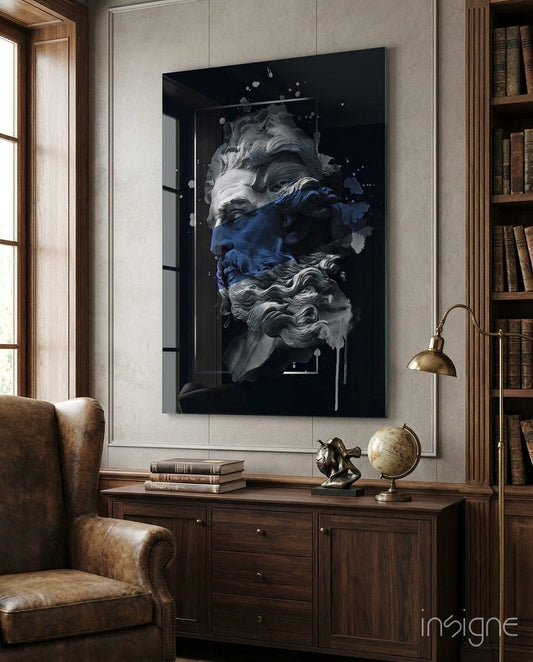 Navy blue and white classical bust artwork on black glass displayed above wooden desk in library study room with leather chair and brass lamp.