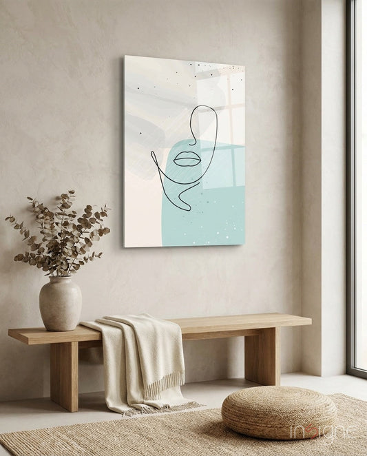 Mint grey line face glass wall art displayed above wooden bench with dried eucalyptus and cream throw.